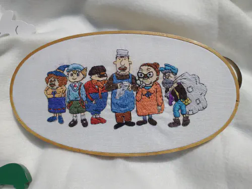 an embroidery hoop depicting characters from the professor layton game